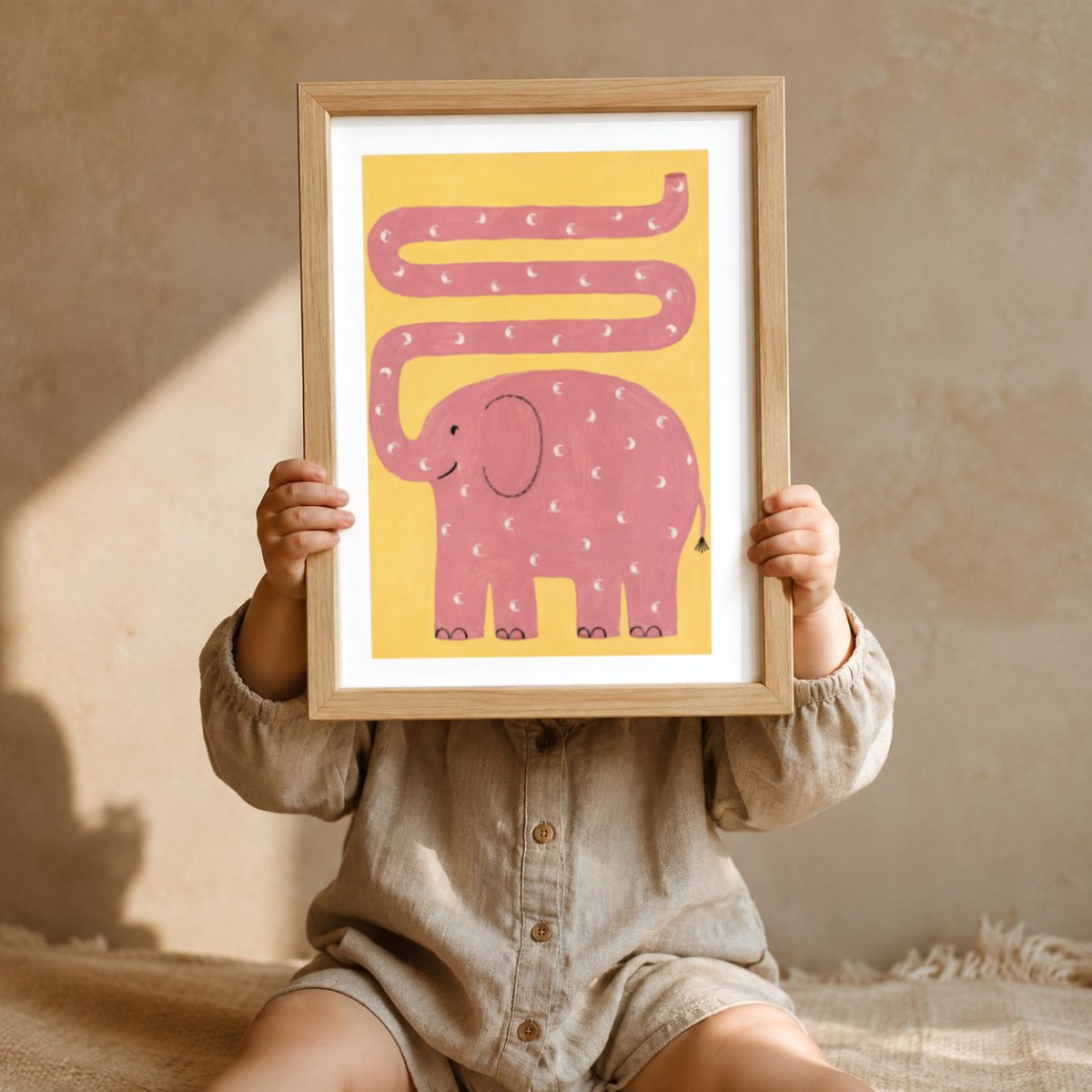 Rosa Elefant Kringeltier Poster – Mockup: Kind hält das Poster im Kinderzimmer